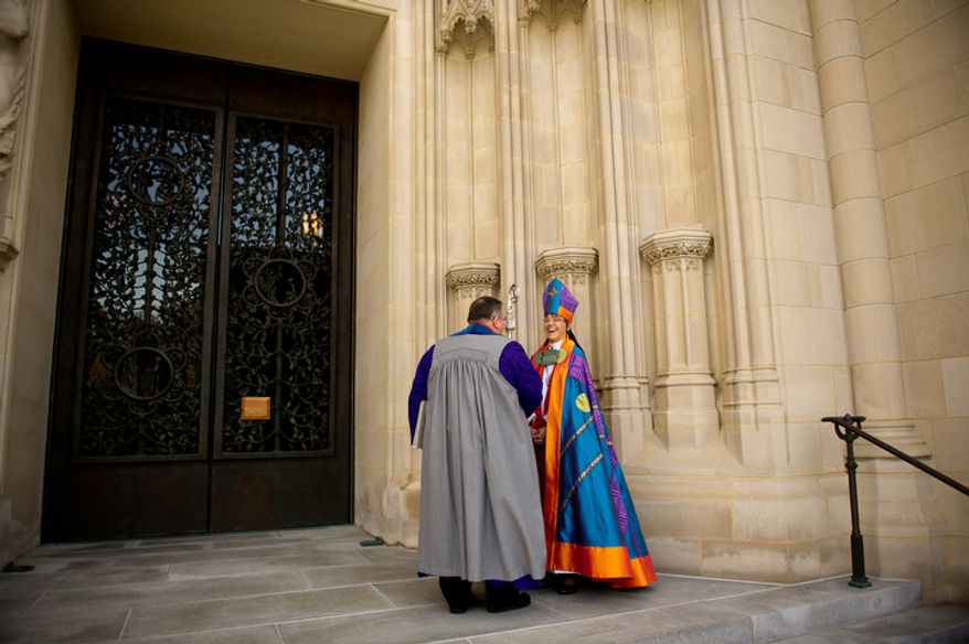 The Reverend Dr. Mariann Edgar Buddle shares a laugh outside with Verger Duke DuTeil before she is consecrated as the ninth bishop of Washington. (Andrew Harnik / The Washington Times)