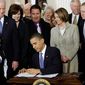 ** FILE ** President Obama signs the health care bill at the White House in Washington on March 23, 2010, flanked by smiling supporters from the House and Senate as well as Victoria Reggie Kennedy (behind Mr. Obama&#x27;s right shoulder), widow of Sen. Edward M. Kennedy, who was a champion of the legislation. (Associated Press)