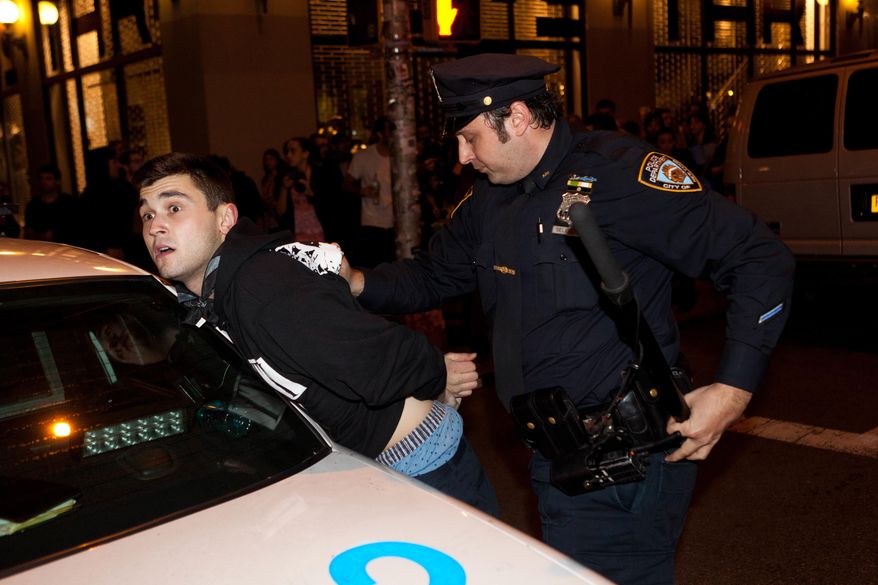 An Occupy Wall Street protester is arrested during a march on Broadway, Tuesday, Nov. 15, 2011, in New York, after police ordered demonstrators to leave their encampment in Zuccotti Park. (AP Photo/John Minchillo)