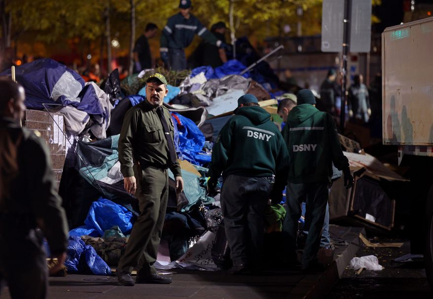 Sanitation workers pile debris from the Occupy Wall Street encampment at Zuccotti Park in New York on Tuesday, Nov. 15, 2011, after police ordered protesters to leave. (AP Photo/Craig Ruttle)