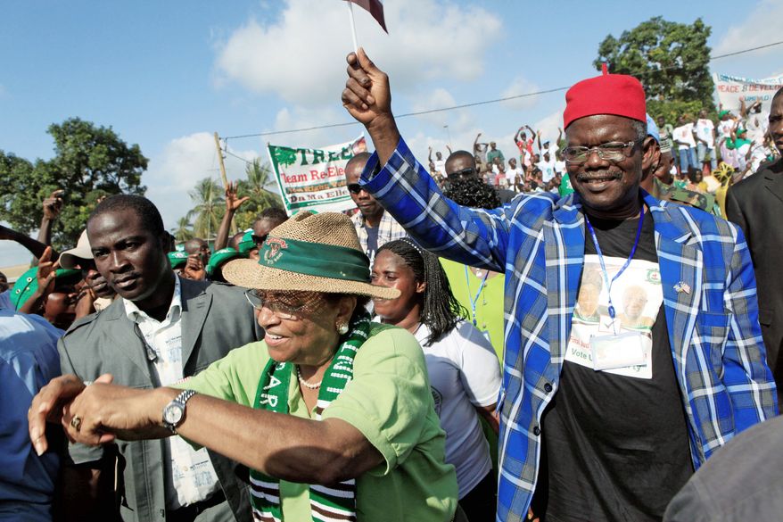 Liberian President Ellen Johnson-Sirleaf (below center) walks with Prince Johnson (below right) at a rally in Monrovia, Liberia, on Nov. 6 before the presidential election two days later. Mrs. Johnson-Sirleaf won re-election and denies making concessions to Mr. Johnson, an ex-warlord linked to atrocities. (Associated Press)