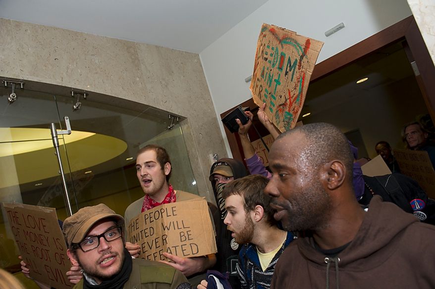 Demonstrators with Occupy D.C. occupy the lobby of the Victor Building in downtown Washington, D.C., Tuesday, Nov. 15, 2011, to show support for the Occupy Wall Street movement. (Rod Lamkey Jr./The Washington Times)