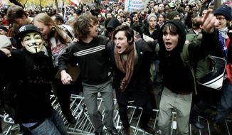 Protesters jump on police barricades on Thursday, Nov. 17, 2011, in New York&#39;s Zuccotti Park, where the Occupy Wall Street movement began two months earlier. Demonstrators from coast to coast joined their call for economic justice. (Associated Press)