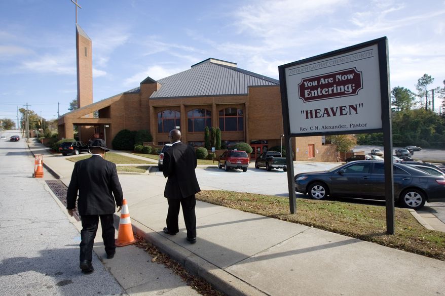 A Security detail walks back to the property of Antioch Baptist Church North, which is the church Republican Presidential hopeful Herman Cain attends, after services on Sunday Nov. 6, 2011. (AP Photo/John Amis)