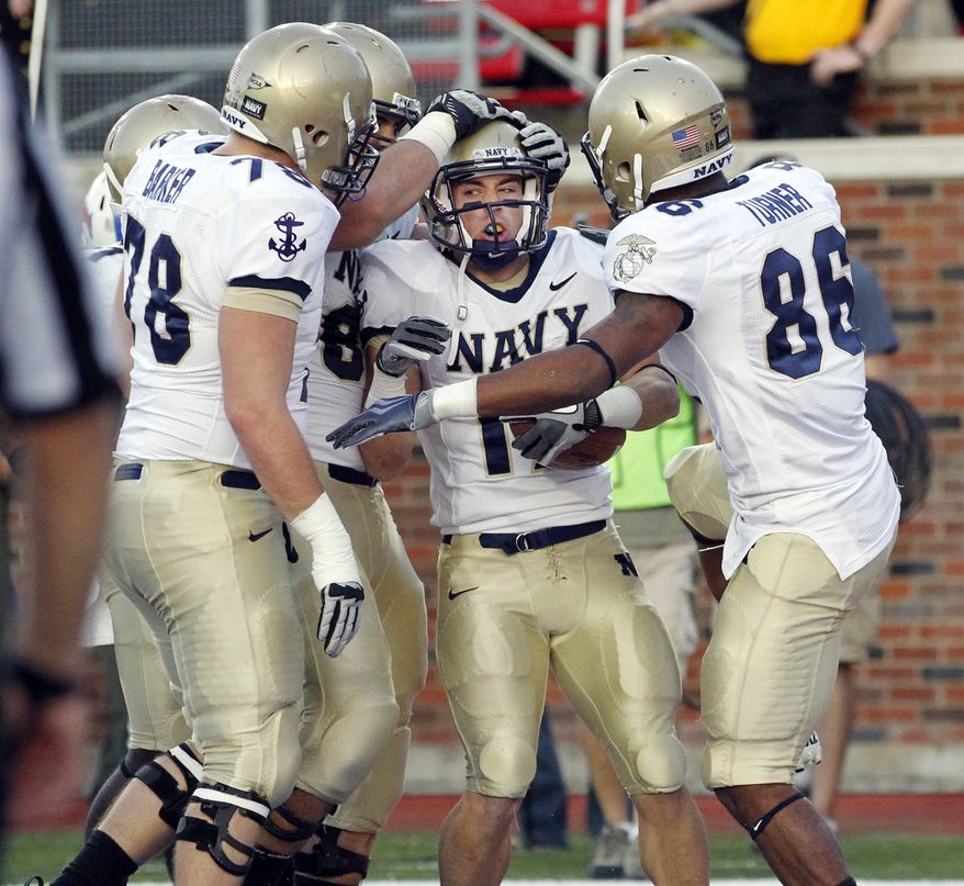 Navy running back Mike Stukel (17) is congratulated by teammates after scoring their final touchdown in the fourth quarter against SMU, Saturday, Nov. 12, 2011, at Gerald J. Ford Stadium in Dallas, Texas. Navy won the game 24-17. (AP Photo/John F. Rhodes)