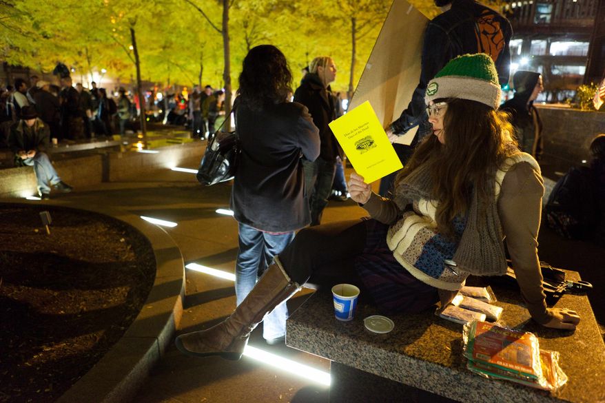 Lauren Belski, 31, of Brooklyn reads in a newly tent-free Zuccotti Park during the early morning hours, Wednesday, Nov. 16, 2011, in New York. (AP Photo/John Minchillo)