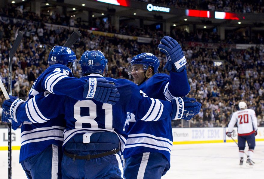 Toronto Maple Leafs' Phil Kessel celebrates his goal with teammates Tyler Bozak and John-Michael Lyles, as Washington Capitals' Troy Brouwer (20) skates away during the second period in Toronto on Saturday, Nov. 19, 2011. Kessel had a goal and an assist in the win. (AP Photo/The Canadian Press, Chris Young)