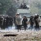 Egyptian riot police advance during clashes Sunday with protesters in Cairo&#39;s Tahrir Square. They battled for a second day with thousands of demonstrators demanding that a date be set for the handover of power from the military to a civilian government. (Associated Press)