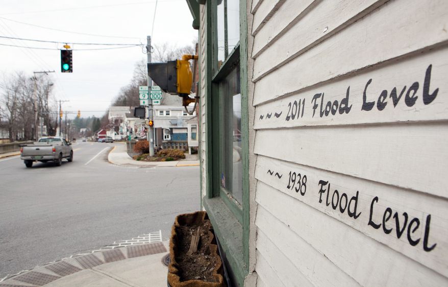 The crest level from two major floods is marked on the side of the Wilmington, Vt., Police Department building. Many of the town's businesses were severely damaged by flooding from Tropical Storm Irene this summer and have not reopened. (Associated Press)