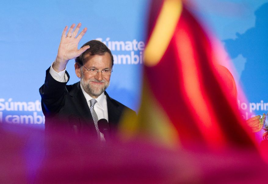 Popular Party candidate Mariano Rajoy waves to gleeful supporters in Madrid on Sunday. With his party winning a huge majority in the Spanish parliament, Mr. Rajoy is set to become the nation's next prime minister. (Associated Press)