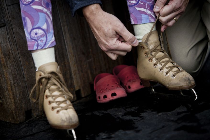 David Diggs, of Washington, D.C., ties up the skates for his daughter, Josie. (T.J. Kirkpatrick/ The Washington Times)