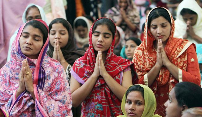 People from the Pakistani Christian community in Karachi, Pakistan, attend a Sunday service at the new St. Peter&#x27;s church. The domed, three-story building towers over the sprawling slum it serves and is the largest yet in the violent, Muslim country. (Associated Press)