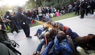University of California, Davis Police Lt. John Pike uses pepper spray to move Occupy UC Davis protesters while blocking their exit from the school&#39;s quad in Davis, Calif., on Nov. 18, 2011. Two campus police officers involved in the pepper-spraying incident were placed on administrative leave two days later. (Associated Press/The Enterprise)