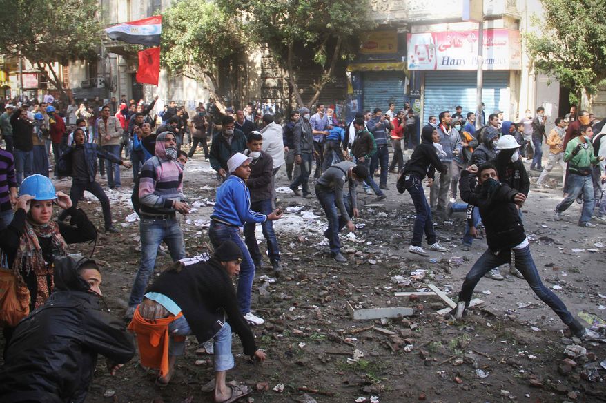 **FILE** Protesters throw stones at Egyptian riot police in Tahrir Square in Cairo on Nov. 21, 2011. Police are clashing for a third day in Cairo's central Tahrir Square with stone-throwing protesters demanding the country's military rulers quickly transfer power to a civilian government. (Associated Press)