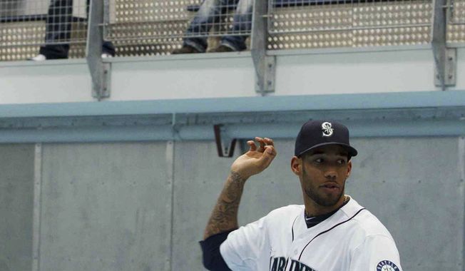 In this photo taken on Nov. 5, 2011, Seattle Mariners outfielder Greg Halman (foreground) is seen during a Big League Tour baseball game in Utrecht, Netherlands. His brother Jason Halman is seen at left in the background. Greg Halman was stabbed to death early Nov. 21, 2011 in Rotterdam, Netherlands, and his brother was arrested as a suspect, Dutch police said. (Associated Press)