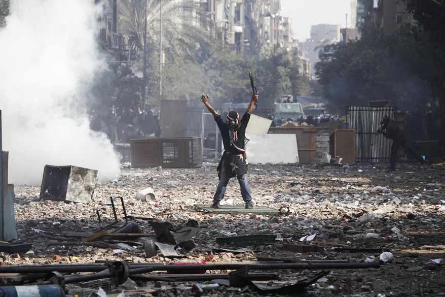 A protester gestures to Egyptian riot police during clashes near Tahrir Square in Cairo on Nov. 23, 2011. (Associated Press)