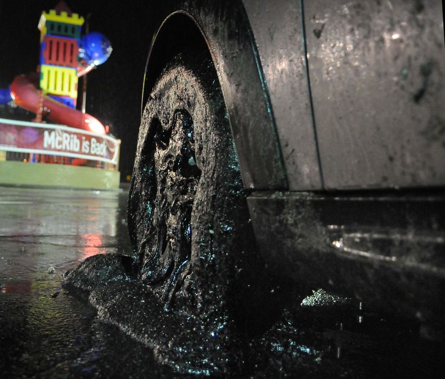 A car with its wheels covered in driveway sealant sits in a parking lot in Harmar, Pa., after exiting the Pennsylvania Turnpike Tuesday night, Nov. 22, 2011. (AP Photo/Valley News Dispatch, Erica Hilliard)