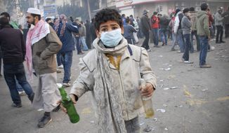 An Egyptian boy holds two Molotov cocktails during clashes with Egyptian riot police, unseen, in Cairo, Egypt, Wednesday, Nov. 23, 2011. (AP Photo/Mohammed Abu Zaid)