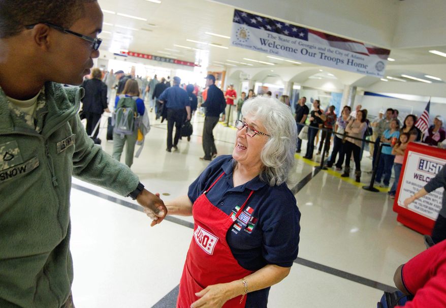 USO volunteer Pat Solomon of Sandy Springs, Ga., greets Army Pfc. Damien Snow, 20, of Rochester, N.Y., as he returns to his base at Fort Benning, Ga., at Hartsfield-Jackson International Airport in Atlanta on Tuesday. "I want to tell them how I feel, and how the USO feels. It's amazing, what they do for the world," Mrs. Solomon says. (Associated Press)