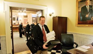 Del. Rob Bell, Albemarle Republican, carries papers and boxes out of the House of Delegates chambers after the House adjourned for the 2009 session in Richmond, Va.  (AP Photo/Steve Helber)