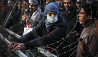 A woman protester attempts to dismantle a barbed wire barricade, newly erected by the Egyptian army, near Tahrir square in Cairo, Egypt, Thursday, Nov. 24, 2011. (AP Photo/Tara Todras-Whitehill)