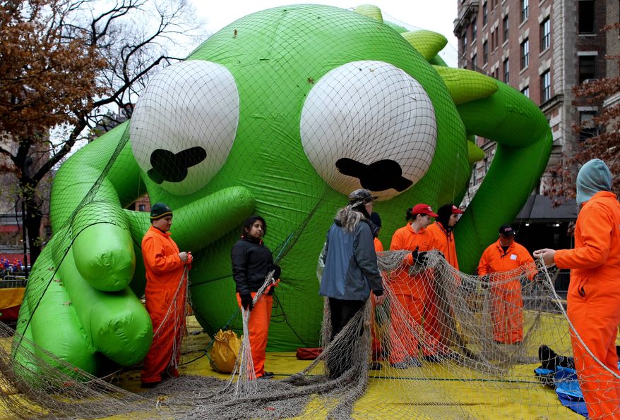 The Kermit the Frog balloon seems to reach out toward balloon handlers with Macy's department store's 85th annual Macy's Thanksgiving Day Parade as they work on another one of 15 giant helium balloons and 44 novelty and specialty balloons Wednesday, Nov. 23, 2011, that will be featured in Thursday's parade in New York. (AP Photo/Craig Ruttle)