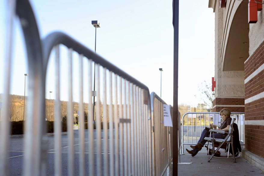 Ann Jackson settles in with her iPad and an energy drink in front of Target in the Wards Crossing Shopping Center in Lynchburg, Va., Thursday, Nov. 24, 2011. Arriving at 3:18 p.m., Jackson immediately called her parents to tell them she was first in line, guaranteeing her a voucher for the best Black Friday deals inside when the store opens its doors at midnight. This weekend, many stores will for the first time use midnight openings along with the usual bevy of deals as they try to lure consumers, whose appetite for good-buys has been increasing since the Great Recession. (AP Photo/News & Daily Advance, Parker Michels-Boyce)