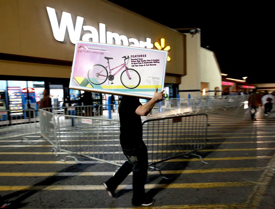A shopper walks to his car Nov. 24, 2011, after purchasing a bike at Walmart in Butler Plaza in Gainesville, Fla. Walmart opened stores on Thursday. (Associated Press/The Gainesville Sun)