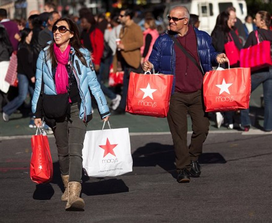 Consumers lug their bags through Herald Square during the busiest shopping day of the year, Friday, Nov. 25, 2011, in New York. Some of the nation's major chain stores opened late Thursday, competing for holiday shoppers on the notoriously busy Black Friday to kick off a period that is crucial for the retail industry. (AP Photo/John Minchillo)
