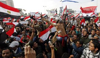 Protesters, including a wounded man, chant slogans and wave Egyptian national flags during a rally in Tahrir Square in Cairo on Nov. 25, 2011. (Associated Press)