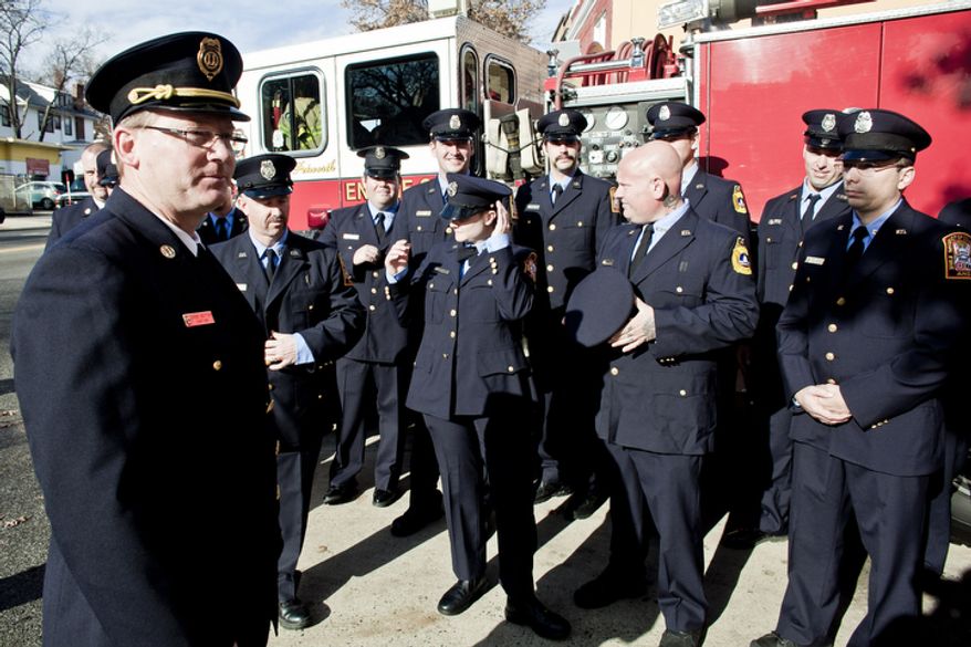 Engine Co. 24 Capt. Chris Sefton, at left, looks over members of his crew after a group photograph during Engine Company 24's centennial celebration.
(T.J. Kirkpatrick/ The Washington Times)