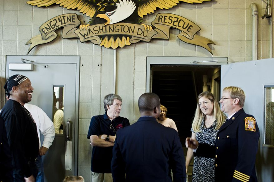 Lou Reid, from left, who served with Engine Co. 24 for 11 years, and Doug Wheeler, a 34-year veteran of the D.C. Fire Department and former Captain of Engine Co. 24, talk with Capt. Chris Sefton, at right, and his wife Stacy during Engine Company 24's centennial celebration.
(T.J. Kirkpatrick/ The Washington Times)