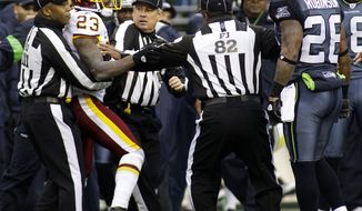 Seattle Seahawks&#39; Michael Robinson and Washington Redskins&#39; DeAngelo Hall are separated by officials after a scuffle in the first half of an NFL football game, Sunday, Nov. 27, 2011, in Seattle. (AP Photo/Ted S. Warren)