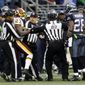 Seattle Seahawks&#39; Michael Robinson and Washington Redskins&#39; DeAngelo Hall are separated by officials after a scuffle in the first half of an NFL football game, Sunday, Nov. 27, 2011, in Seattle. (AP Photo/Ted S. Warren)