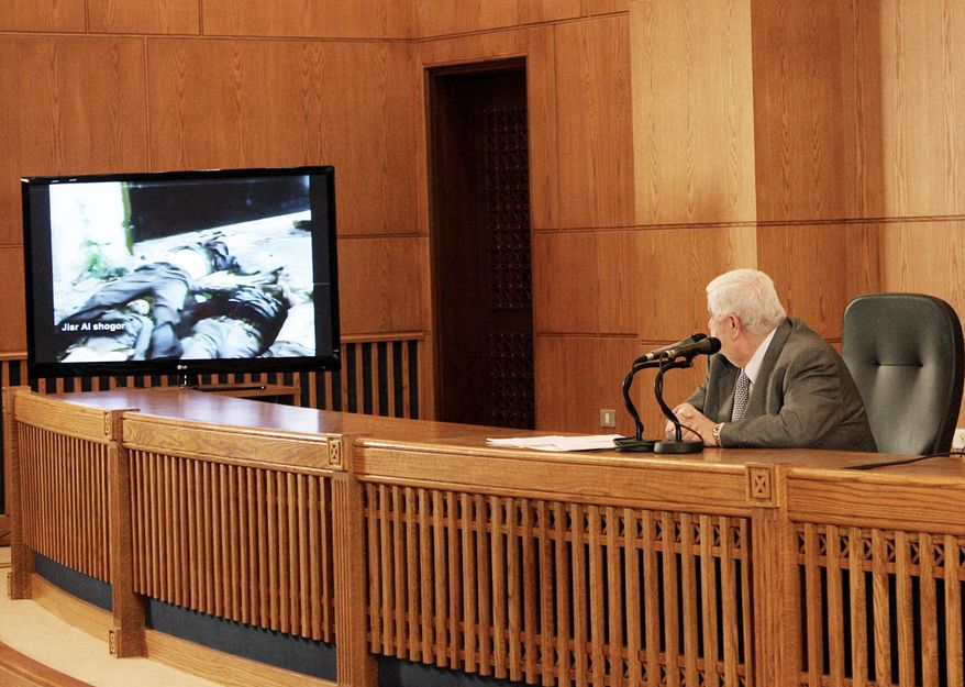 Foreign Minister Walid al-Moallem watches videos of corpses during a news conference Monday to bolster the Syrian regime's contention that armed gangs are behind the country's violence. A U.N. probe condemns the regime for violence against protesters.