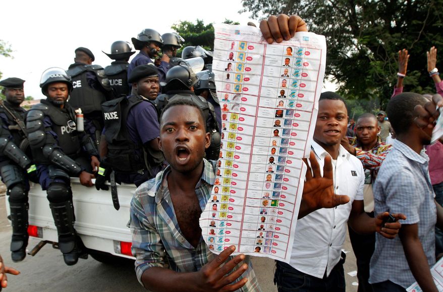Supporters of opposition candidate Etienne Tshisekedi display what they claim are bogus election ballots they say were found in the Bandal commune of Kinshasa, Democratic Republic of Congo, on Monday. (Associated Press)