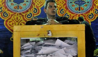 An Egyptian election official waits for the opening of ballot boxes at a vote-counting center in Cairo on Tuesday. &quot;These elections are completely different from anything we&#39;ve had before,&quot; said taxi driver Mohammed Farouk. (Associated Press)
