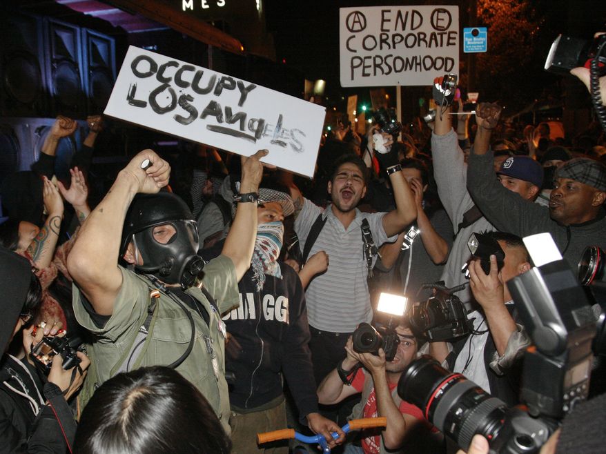 Wall Street protesters dance to music as they remain at the camp in front of Los Angeles City Hall in Los Angeles on Sunday, Nov. 27, 2011. Los Angeles Mayor Antonio Villaraigosa stated Friday that the protesters' campsite will be dismantled, beginning at 12:01 a.m. Monday. (AP Photo/Jason Redmond)