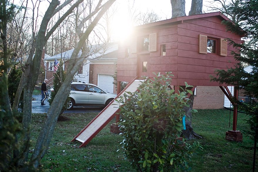 A treehouse sits in the front yard of the Grapin family home in Falls Church, Va., on Nov. 30, 2011. Mark Grapin, walking in background, an Army National Guard chief warrant officer, testified before the Fairfax County Board of Zoning and Appeals Wednesday in support of an ordinance that would allow him to keep a treehouse in his front yard. An initial hearing in September rebuffed Grapin's attempt to keep his treehouse in place for his two sons, but an appeal was allowed and Wednesday's hearing granted an ordinance that gives the family five years until the treehouse must be removed. (T.J. Kirkpatrick/The Washington Times)