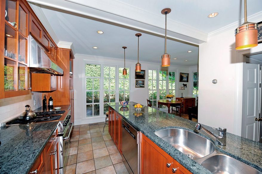 The kitchen and breakfast room have been renovated. The kitchen features granite counters, wood and glass-paneled cabinets, stainless steel appliances and under cabinet lighting.