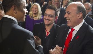 President Barack Obama greets U2 front man Bono, center, and Muhtar Kent, chairman of the Board and chief executive officer of The Coca-Cola Company, right, after speaking during a World AIDS Day event at George Washington University in Washington, Thursday, Dec. 1, 2011. (AP Photo/Carolyn Kaster)