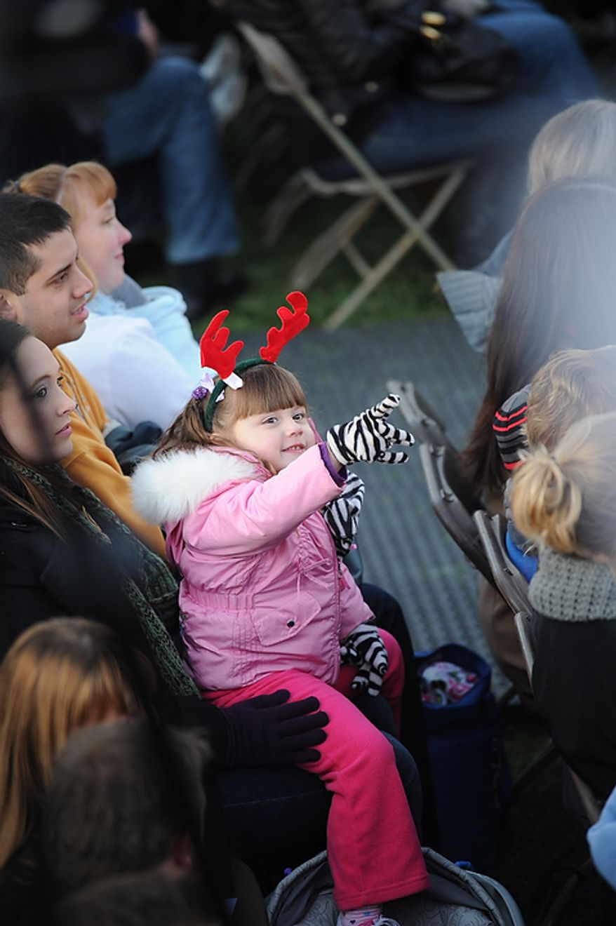A girl points up to the sky as she joins hundreds of others during The National Christmas Tree Lighting 2011 on The Elipse in Washington, DC, Thursday, December 1, 2011. (Rod Lamkey Jr/ The Washington Times)