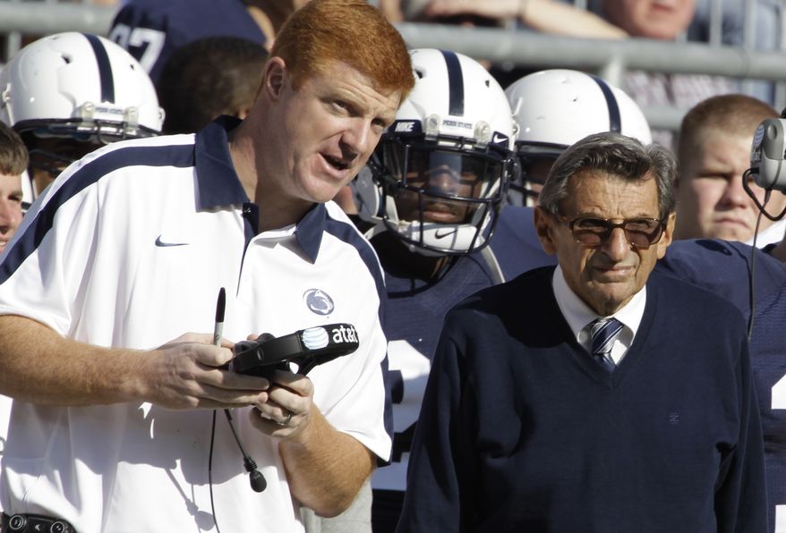 FILE - In this Oct. 8, 2011 file photo, Penn St. assistant football coach Mike McQueary, left, talks with head coach Joe Paterno during an NCAA college football game against Iowa, in State College, Pa. Penn State Athletic Director Tim Curley and Gary Schultz, the school's senior vice president for business and finance, face arraignment Monday, Nov. 7, 2011, on charges they lied to a grand jury investigating former defense coordinator Jerry Sandusky and failed to properly report suspected child abuse, a case that has left fans reeling. In 2002, State Attorney General Linda Kelly said, a graduate assistant, identified by two people familiar with the investigation as McQueary, saw Sandusky sexually assault a naked boy, estimated to be about 10 years old, in a team locker room shower. (AP Photo/Gene Puskar, File)