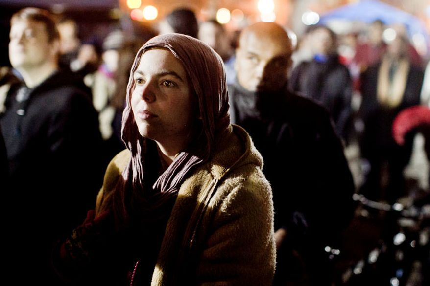 Occupiers watches as Park Police use a cherry picker to pull a protestor off the roof of a new structure the was erected in McPherson Square, in Washington, D.C. on Dec. 4, 2011.
(T.J. Kirkpatrick/ The Washington Times)