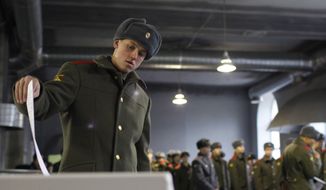 A Russian soldier casts his ballot as others stand in line at a polling station in Moscow on Sunday, Dec. 4, 2011.  (AP Photo/Alexander Zemlianichenko Jr.)