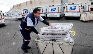 A letter carrier for the U.S. Postal Service moves a cart of mail to his truck. (Associated Press)
