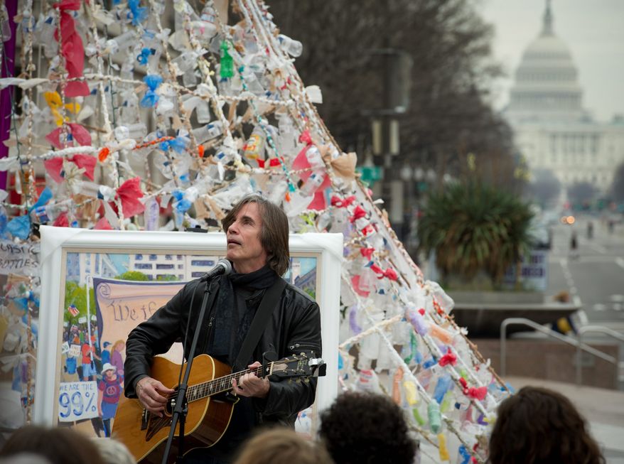 With the U.S. Capitol in the distance, singer Jackson Browne performs for a small crowd at Freedom Plaza, the site of a protest encampment, on Monday. (Rod Lamkey Jr/ The Washington Times)