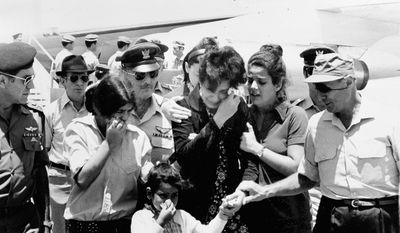 Israeli Defense Minister Moshe Dayan (right) comforts the family of slain military attache Joseph Alon on July 2, 1973.  (Associated Press)