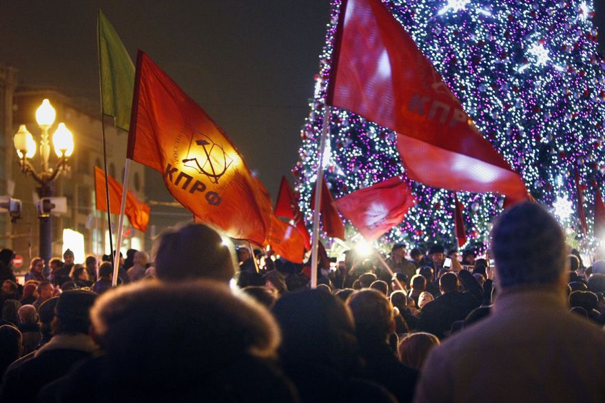 Russian Communist Party supporters hold flags with the party colors and emblem during a demonstration in Moscow on Monday, Dec. 5, 2011, to protest the official results of parliamentary elections. (AP Photo/Alexander Zemlianichenko)