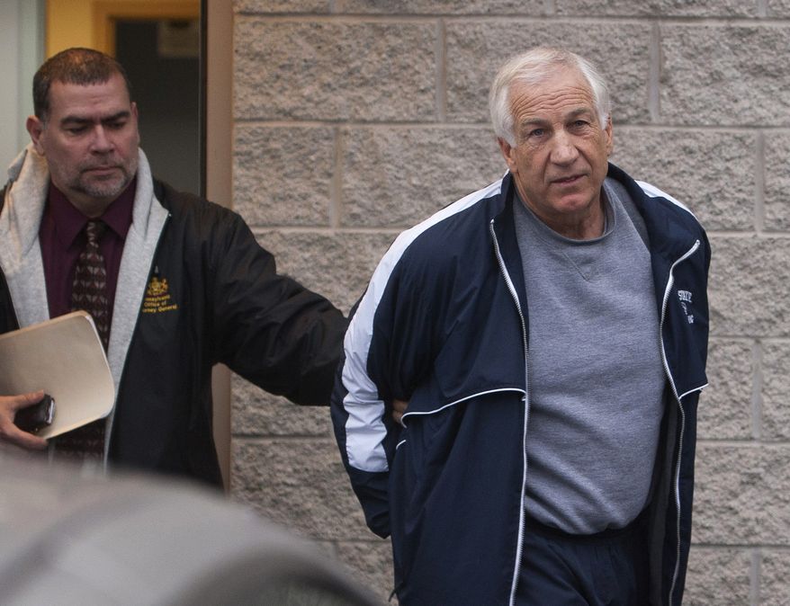 Former Penn State assistant football coach Jerry Sandusky, right, leaves the office of Centre County District Justice Daniel A. Hoffman under escort by Pennsylvania State Police and Attorney General's Office officials in Bellefonte, Pa., on Thursday, Dec. 7, 2011. Sandusky was arrested and jailed Wednesday on new child sex abuse charges brought by two new accusers, including one who claims Sandusky molested him numerous times in a basement bedroom, according to authorities. (AP Photo/The Patriot-News, Andy Colwell)